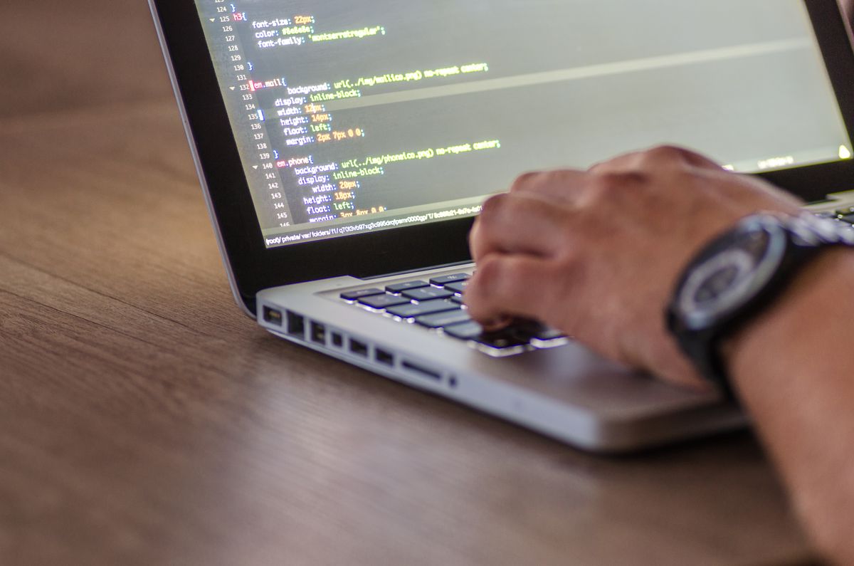Tangan mengetik pesan chat di keyboard laptop