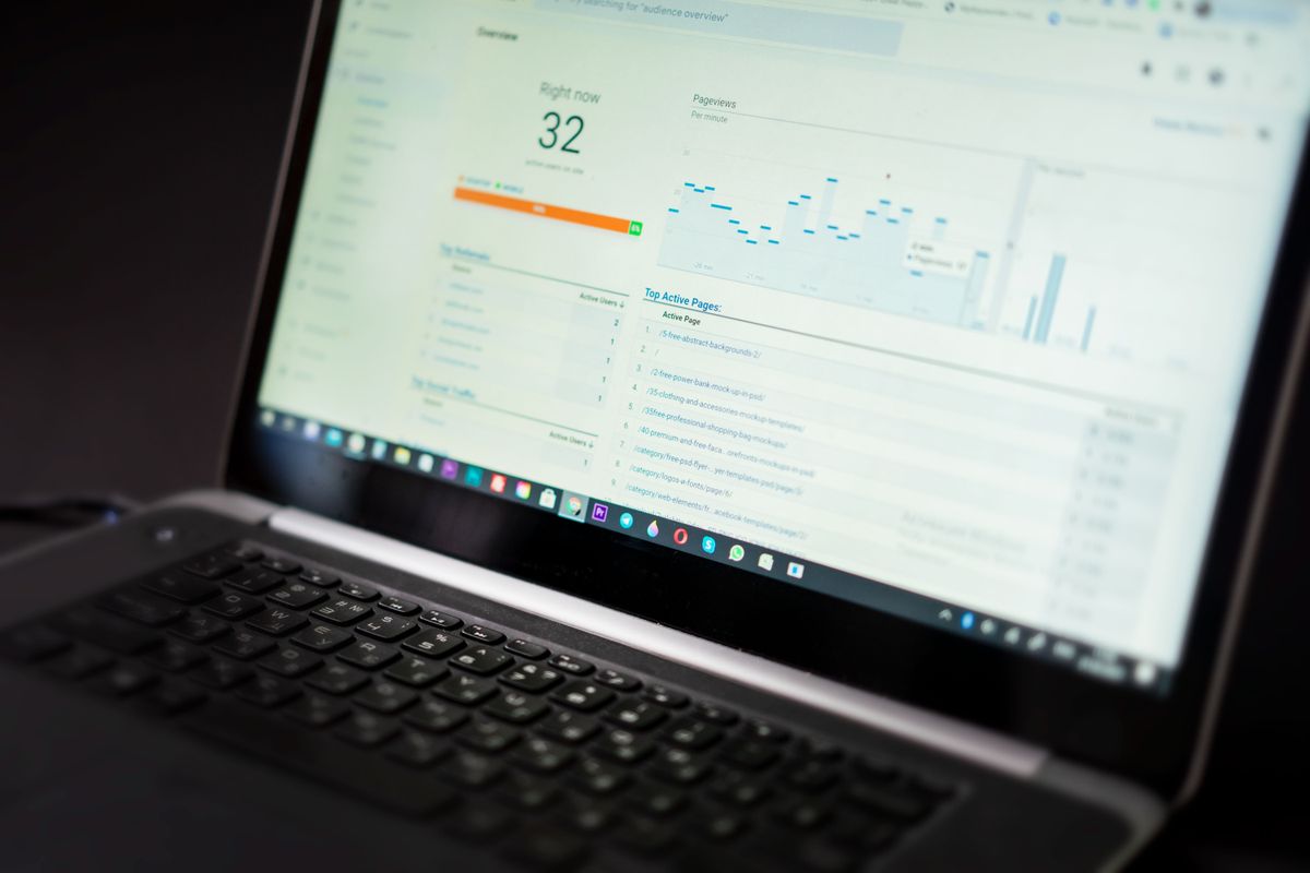 Laptop menampilkan dashboard data dan alat analisis